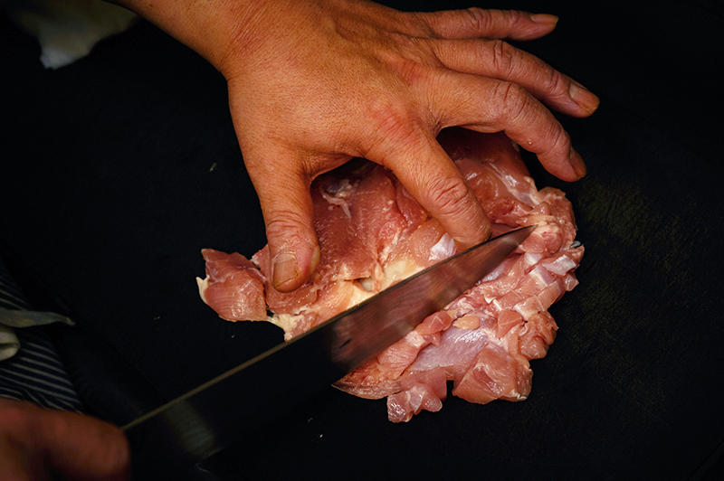鶏モモ肉は筋を断ち切る方向（→Point3）に、1cmくらいの間隔で切り込みを全面に入れる。皮までは切らないように注意。