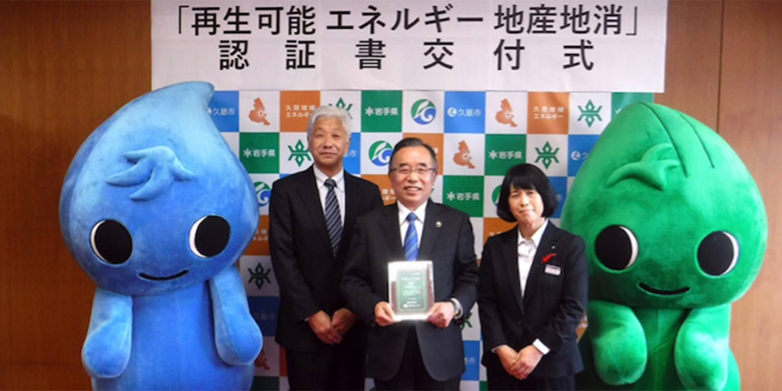 Kuji Regional Energy CEO Haruo Wakabayashi (left) receives a certificate for the local production and consumption of renewable energy from the mayor of Kuji city, Joji Endo (center) | Courtesy of Kuji Regional Energy Co Ltd