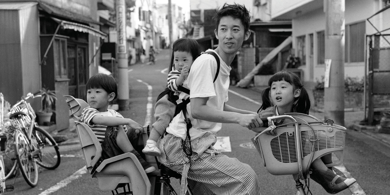 Three children take a ride on their father’s bicycle, 2009